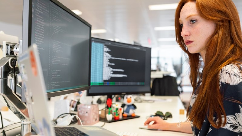 A woman in an office researching customer journey orchestration during a meeting